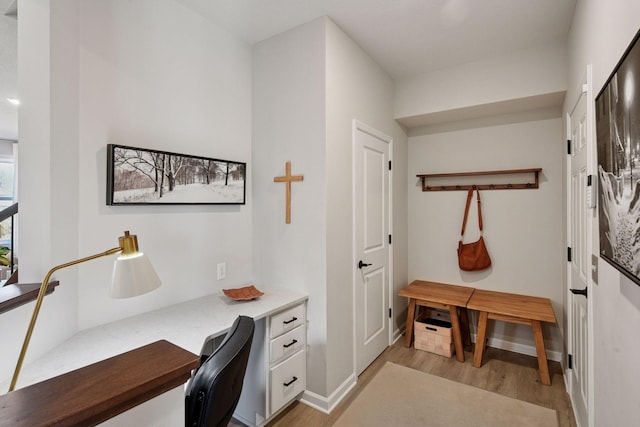 home office with light wood-style floors, baseboards, and built in study area