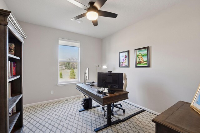 carpeted home office with baseboards and a ceiling fan