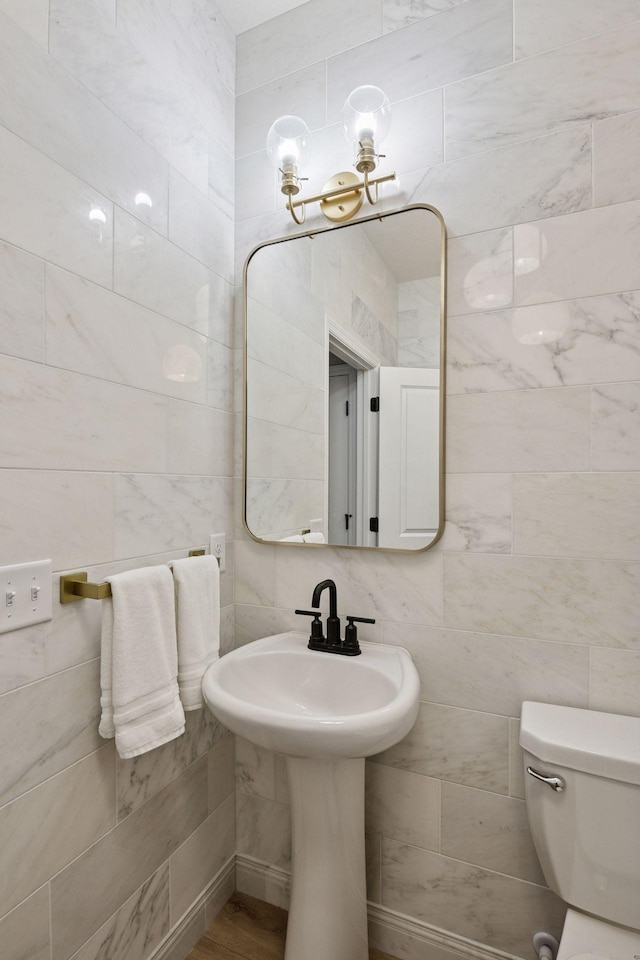 bathroom with tile walls and toilet