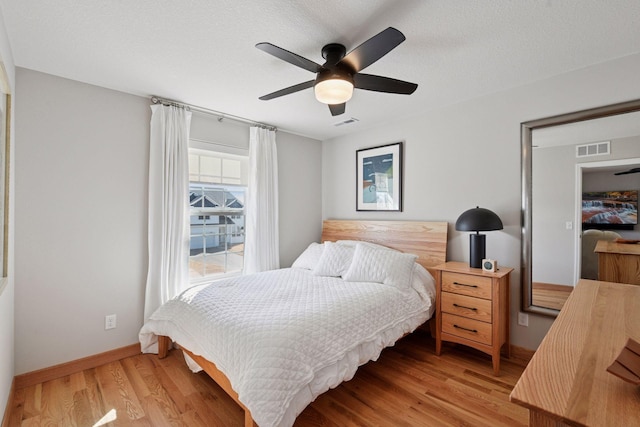 bedroom with a ceiling fan, baseboards, visible vents, and light wood-style flooring