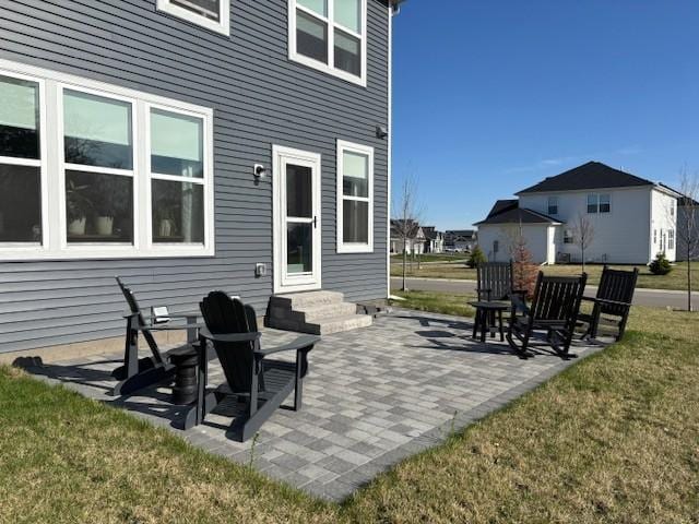 back of property featuring a patio, a yard, and entry steps