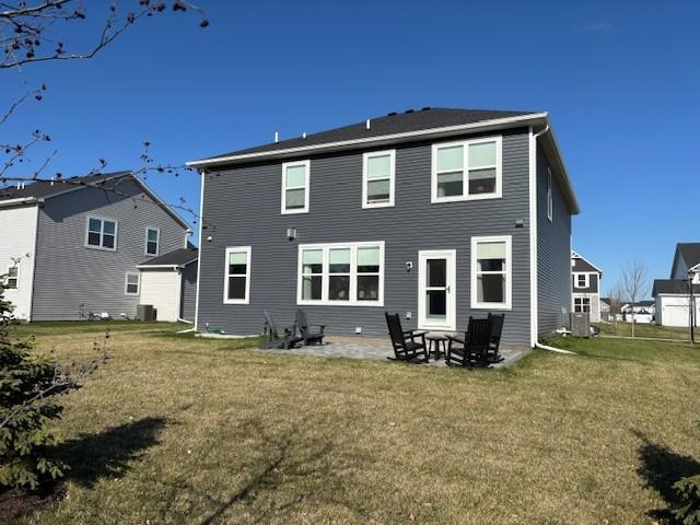 rear view of house featuring a lawn, a patio, and cooling unit