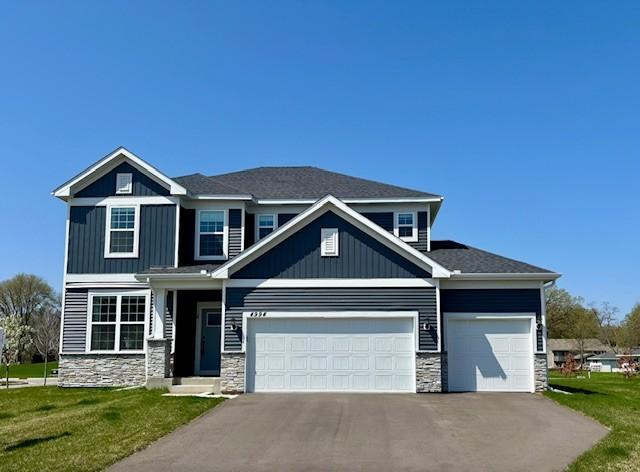 4994 Obsidian Way, Victoria, MN 55386 - view of front facade with stone siding, asphalt driveway, a garage, and a front yard