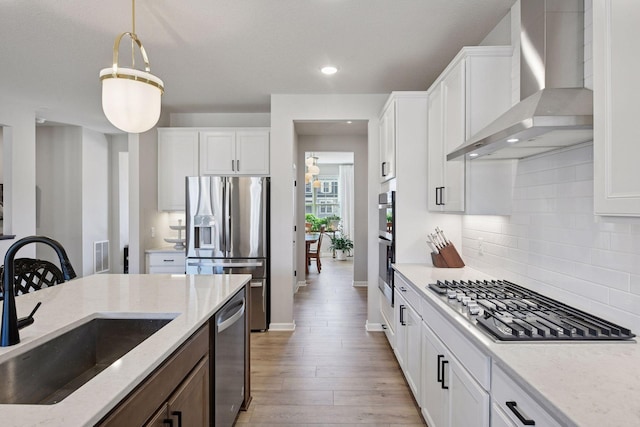 4994 Obsidian Way, Victoria, MN 55386 - kitchen featuring wall chimney range hood, stainless steel appliances, a sink, decorative backsplash, and light stone countertops