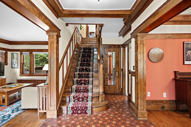 2511 12th Ave N, Minneapolis, MN 55411 - foyer entrance featuring ornate columns, stairway, radiator heating unit, ornamental molding, and wood finished floors