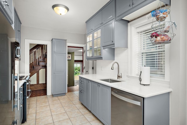 2511 12th Ave N, Minneapolis, MN 55411 - kitchen with appliances with stainless steel finishes, gray cabinets, a sink, backsplash, and light tile patterned flooring
