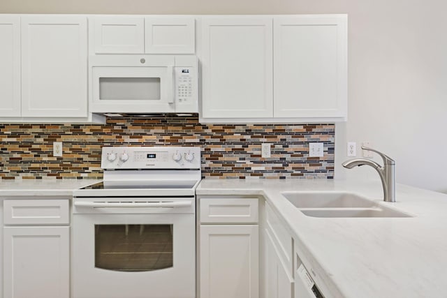kitchen featuring a sink, white appliances, white cabinetry, and light countertops