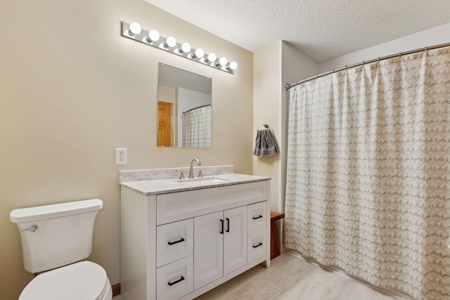 full bath featuring toilet, vanity, and a textured ceiling