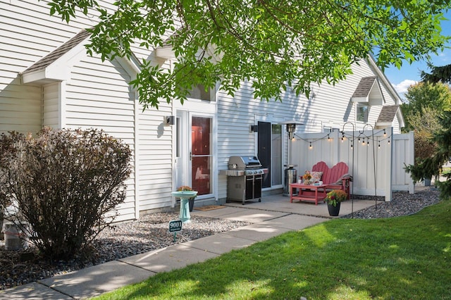 exterior space featuring a patio area, fence, and a lawn