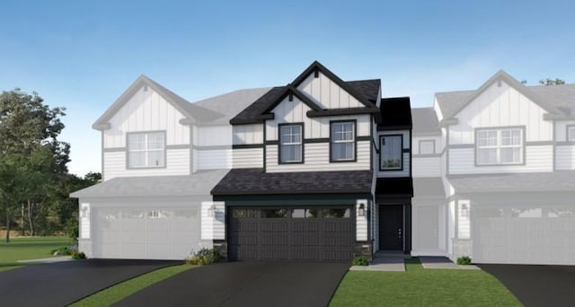 view of front of home featuring a garage, board and batten siding, a front yard, and aphalt driveway