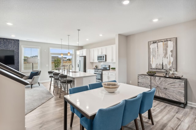 dining space with recessed lighting, baseboards, and light wood-style floors
