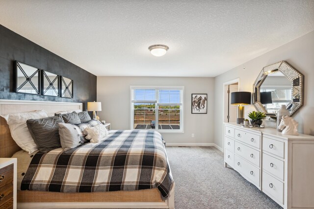 bedroom with baseboards, a textured ceiling, and light carpet