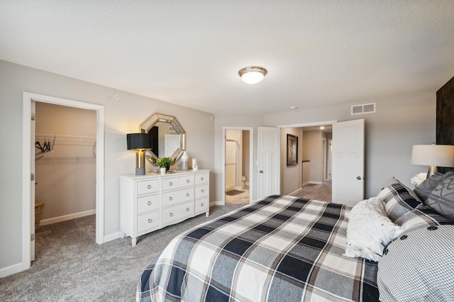 bedroom featuring light carpet, baseboards, a spacious closet, visible vents, and a closet