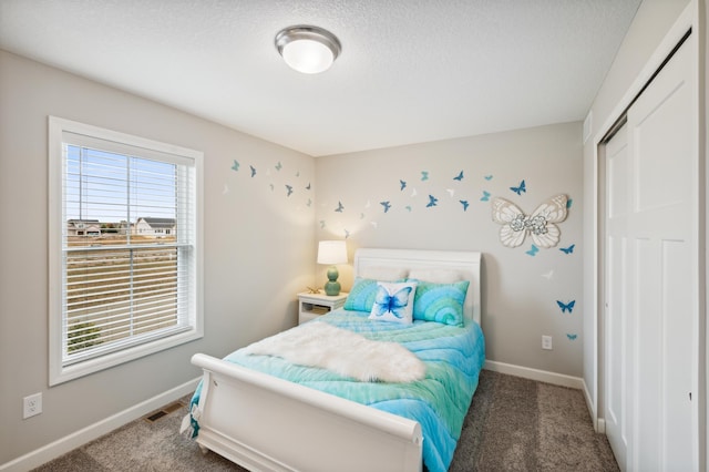 carpeted bedroom with baseboards, a textured ceiling, and visible vents