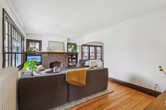 2170 Palace Ave, Saint Paul, MN 55105 - living area featuring ornamental molding, wood finished floors, a fireplace, baseboards, and arched walkways
