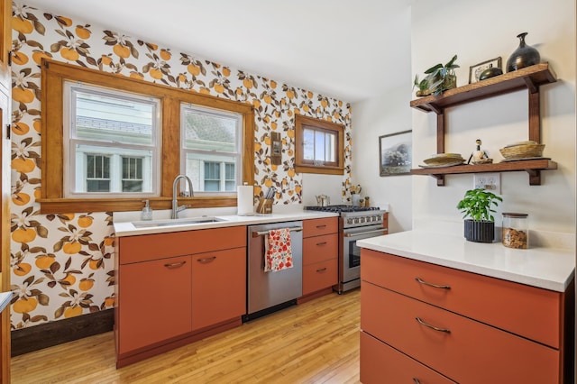 2170 Palace Ave, Saint Paul, MN 55105 - kitchen with open shelves, wallpapered walls, a sink, light wood-style flooring, and stainless steel appliances