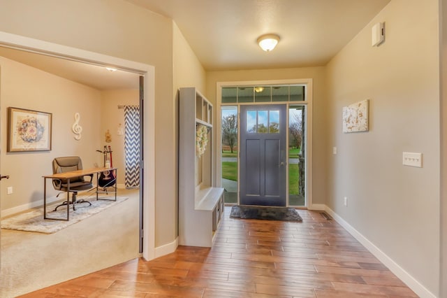 entrance foyer with baseboards and wood finished floors