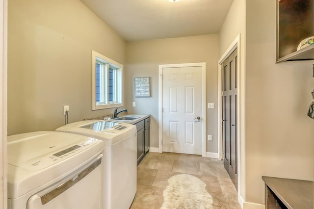laundry room with washing machine and dryer, cabinet space, a sink, baseboards, and light tile patterned floors