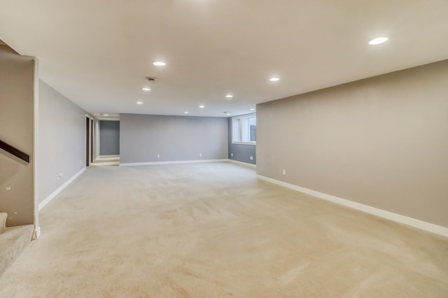 finished basement with recessed lighting, baseboards, stairs, and light colored carpet
