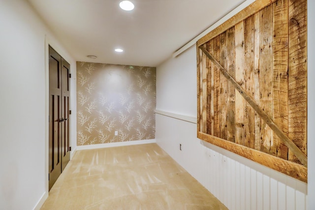spare room featuring carpet floors, baseboards, wallpapered walls, an accent wall, and recessed lighting