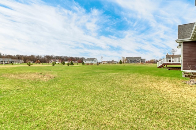 view of yard featuring a residential view and a wooden deck