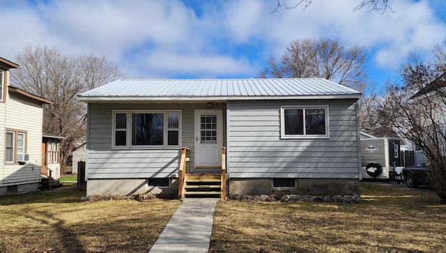 bungalow-style home featuring metal roof and a front yard