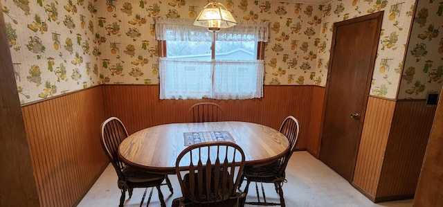 dining space featuring light floors and wainscoting