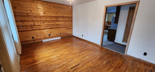 spare room featuring baseboards, visible vents, and hardwood / wood-style floors