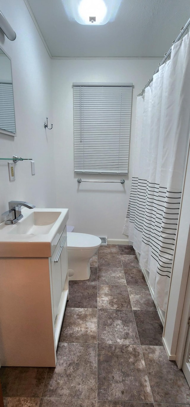 bathroom with vanity, visible vents, toilet, baseboards, and a shower with shower curtain