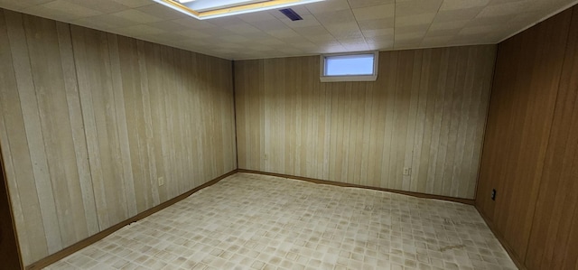 unfurnished room featuring wooden walls