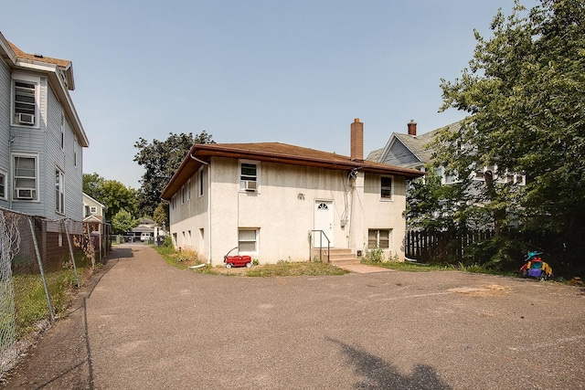 914 Burr St, Saint Paul, MN 55130 - back of house featuring fence, a chimney, and stucco siding