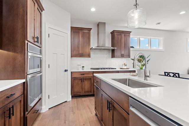 7521 Ocean Ave, Otsego, MN 55330 - kitchen with light wood-style floors, light countertops, wall chimney exhaust hood, a sink, and stainless steel appliances