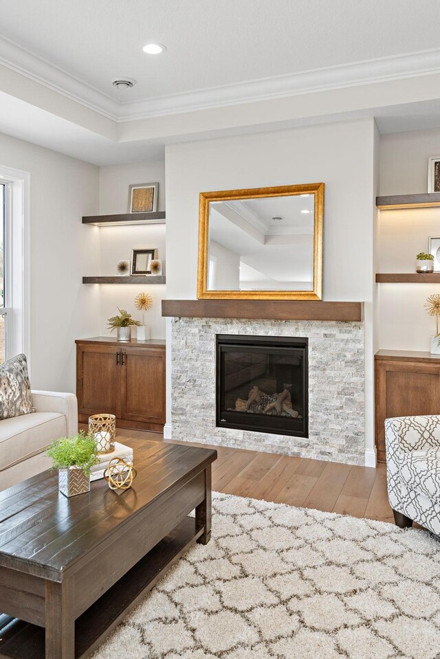 7521 Ocean Ave, Otsego, MN 55330 - living room featuring a stone fireplace, visible vents, wood-type flooring, ornamental molding, and recessed lighting