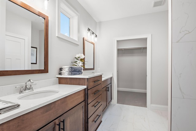 7521 Ocean Ave, Otsego, MN 55330 - bathroom featuring visible vents, vanity, baseboards, marble finish floor, and a spacious closet