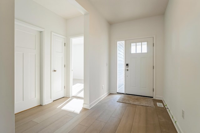 entrance foyer featuring baseboards, light wood-style flooring, and visible vents