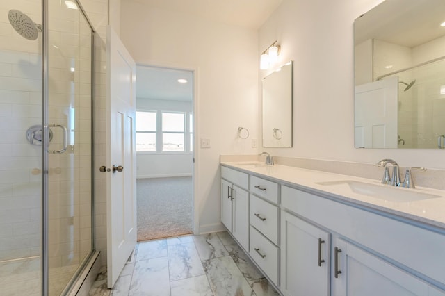 full bathroom featuring double vanity, a sink, marble finish floor, and a stall shower