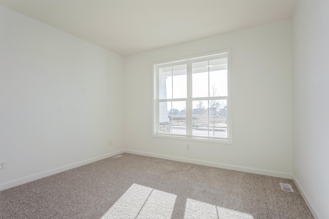 unfurnished room featuring carpet flooring, baseboards, and visible vents