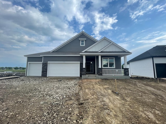 9735 49th St NE, Saint Michael, MN 55376 - craftsman house with covered porch, a garage, gravel driveway, board and batten siding, and stone siding