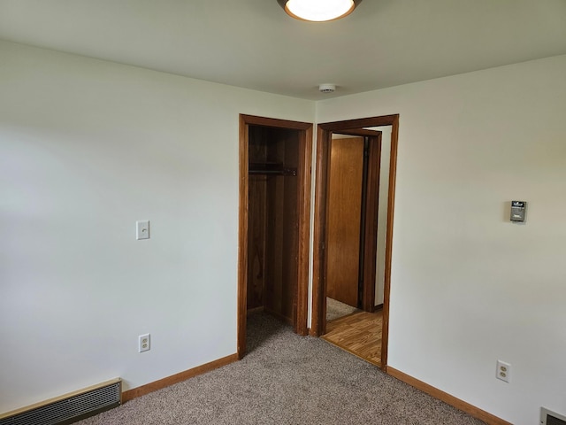 unfurnished bedroom featuring baseboards, carpet floors, and a closet