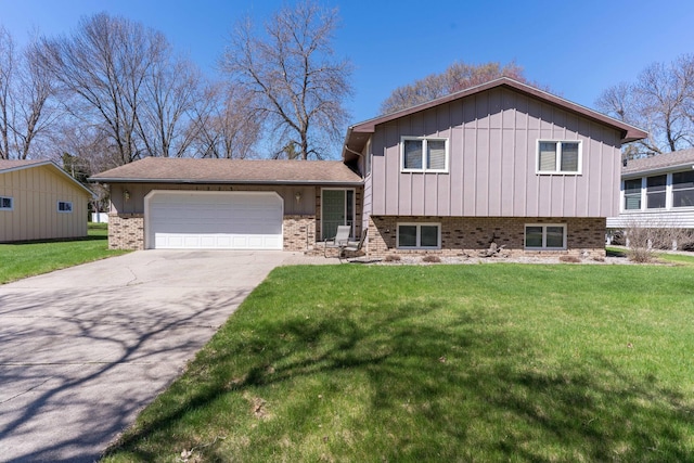 split level home featuring board and batten siding, a front yard, a garage, brick siding, and concrete driveway