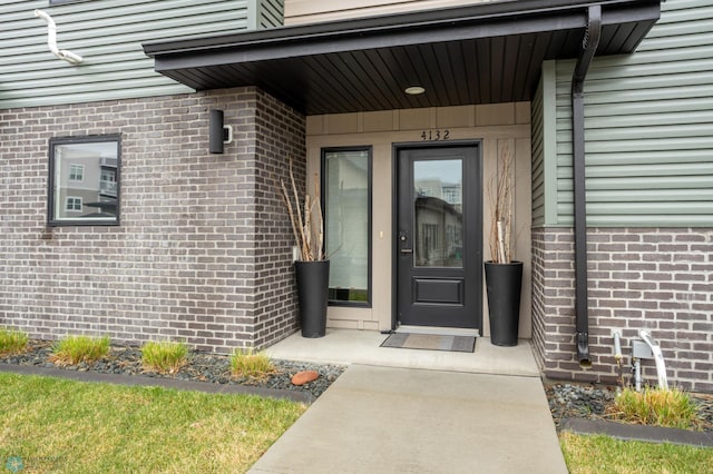 entrance to property featuring brick siding