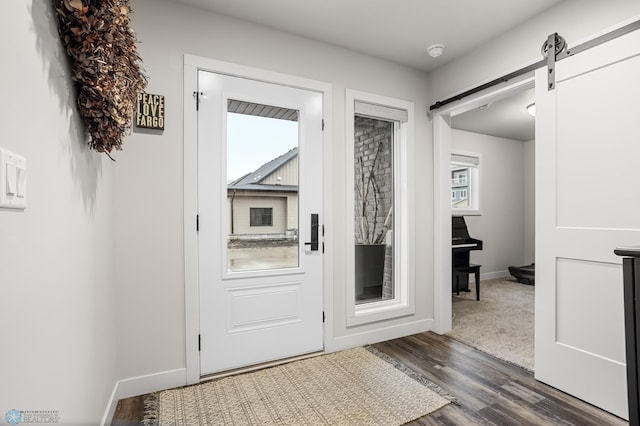 doorway featuring baseboards, dark wood-style floors, and a barn door