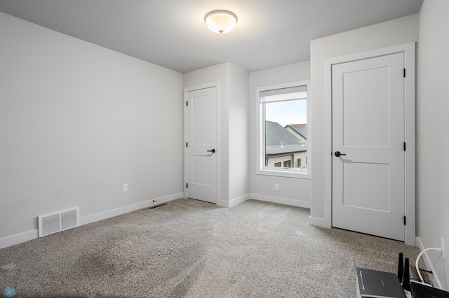 unfurnished bedroom with carpet floors, baseboards, and visible vents