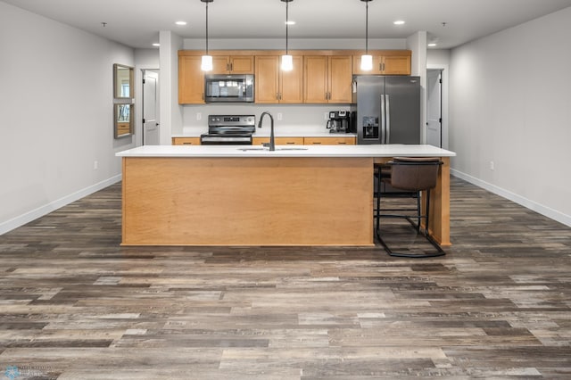 kitchen featuring recessed lighting, appliances with stainless steel finishes, a center island with sink, and a sink