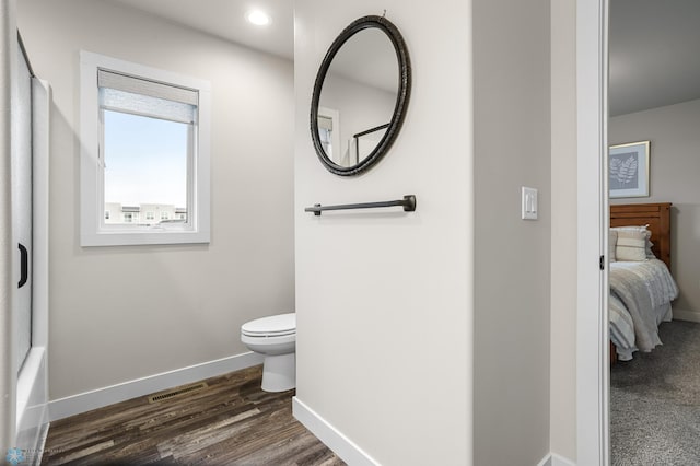 ensuite bathroom featuring toilet, recessed lighting, baseboards, wood finished floors, and visible vents