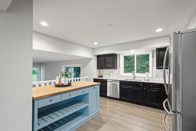 6360 Teton Ln, Chanhassen, MN 55317 - kitchen with appliances with stainless steel finishes, butcher block counters, decorative backsplash, healthy amount of natural light, and recessed lighting