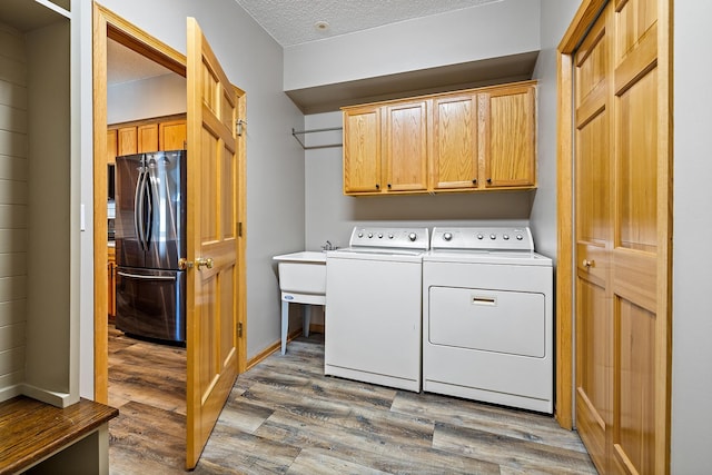 14012 54th Ave N Unit 4, Plymouth, MN 55446 - clothes washing area with washing machine and clothes dryer, cabinet space, and wood finished floors