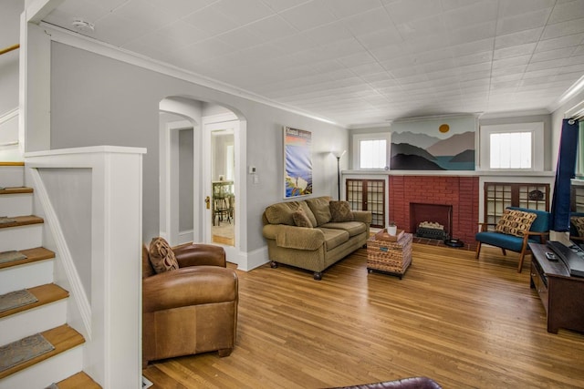 1449 Laurel Ave, Saint Paul, MN 55104 - living area with ornamental molding, stairs, a fireplace, wood finished floors, and arched walkways