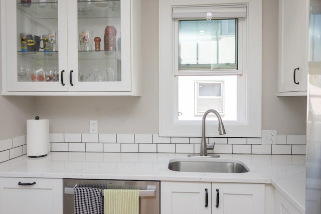 1449 Laurel Ave, Saint Paul, MN 55104 - kitchen with a sink, stainless steel dishwasher, glass insert cabinets, white cabinets, and backsplash