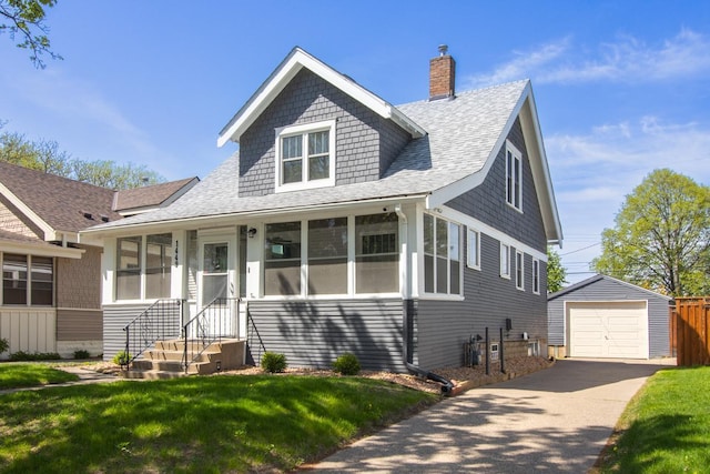 1449 Laurel Ave, Saint Paul, MN 55104 - view of front of house with roof with shingles, an outbuilding, a chimney, a detached garage, and asphalt driveway